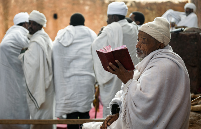 A orthodox deacon reading a bible in Lalibela (Ethiopia - 2017)