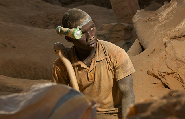 After 7 hours of work into the shaft, the miner takes a break. He is covered with dust from head to foot. For digging the gold, only rudimentary tools are used: a cheap flashlight tied to the head with an elastic tattered band and a small pickaxe so-called “Soulikoudouni”.