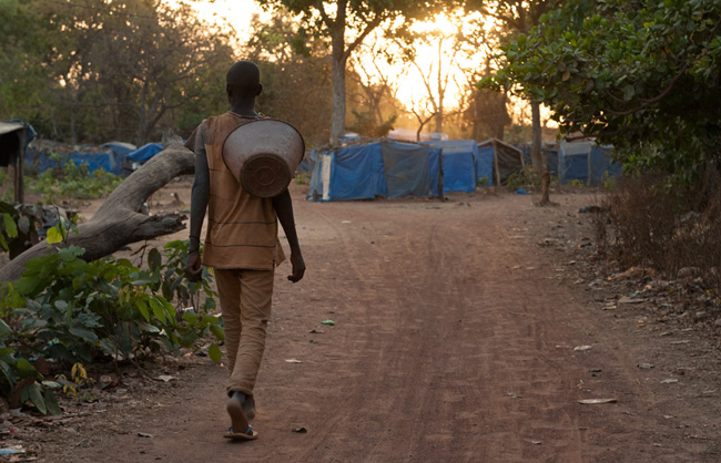 A young teenager is coming back to the camp after a long day of work.