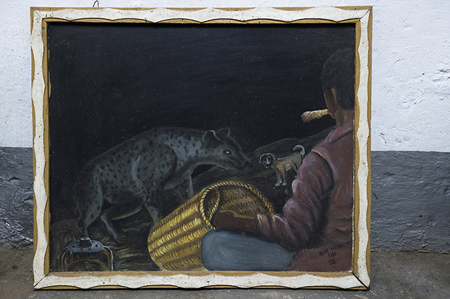 At the Harari National Cultural Center in Harar, a painting from 1990 depicts Yusuf Salleh, Abbas's father, feeding the hyenas. 
Much more than a tourist attraction, this ceremonial is intertwined with the city's history itself. After nearly half a century of daily feeding, Yusuf, Abbas's father, passed the torch to his son, who was barely fifteen at the time. Since then, Abbas has looked after the hyenas with the same dedication as his father before him.