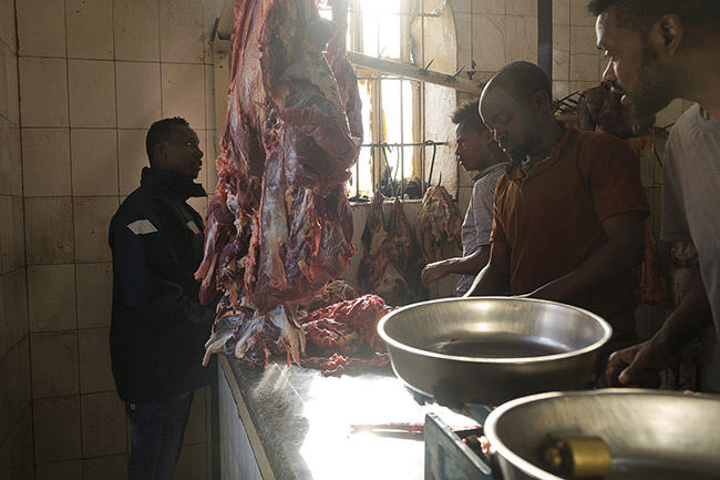 Abbas in a butcher shop at the Gidir Magala meat market in Harar, Ethiopia. 
This is where Abbas goes every morning to buy fresh meat for the hyenas.