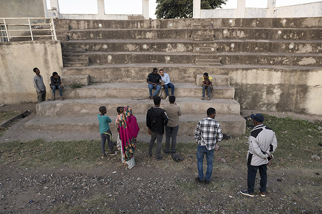 Abbas shows off his 'domesticated' hyena near the site where he feeds wild hyenas daily. 
Like an animal trainer, Abbas aims to train his hyena to perform a few tricks and entertain passing tourists in the city. Meanwhile, for a few hundred birrs (Ethiopian local currency), he readily invites curious onlookers to approach and capture photos of the wild animal trained to obey humans.
