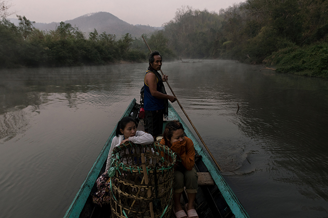 In the morning mist of the Pai River, before pulling up his fishing nets, So Prang drops Rosa and Christina off at the edge of the forest for their daily picking activities.