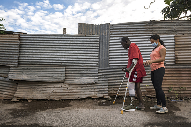 Pauline, a private physiotherapist in Mayotte, provides rehabilitation care directly on the street to her leg amputee patient. Mayotte - 2021