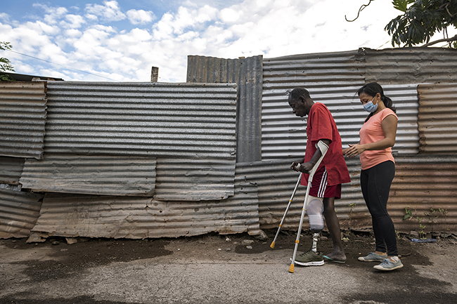 Pauline, a private physiotherapist in Mayotte, provides rehabilitation care directly on the street to her leg amputee patient. Mayotte - 2021