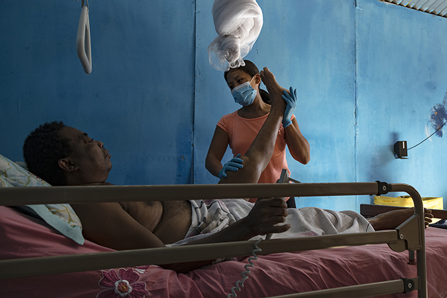 The massages given by Pauline, a physiotherapist in Mayotte, are essential for the daily comfort of this isolated bedridden man. Mayotte - 2021