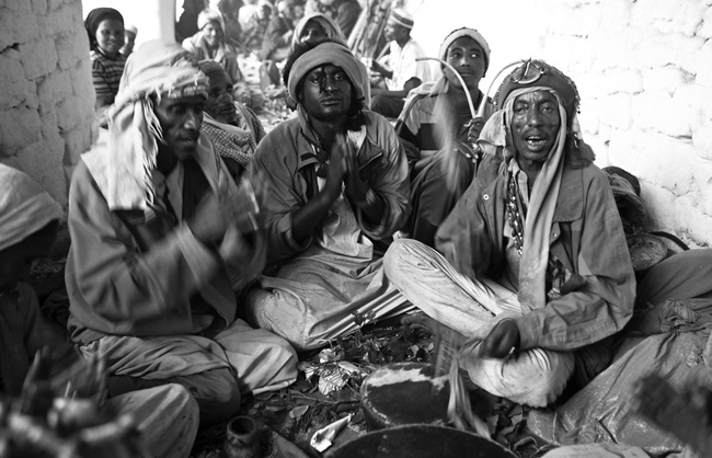 Sitting in groups, the pilgrims sing, dance and pray Sheikh Hussein, the holy man. All rituals are accompanied by Qat, the exhilarating and stimulating plant wildly consumed throughout the Horn of Africa. 